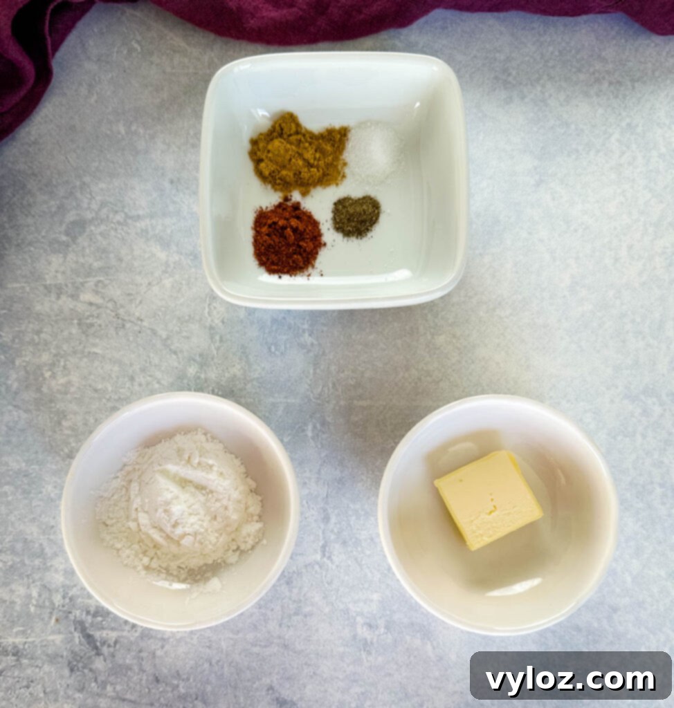 Small white bowls containing various spices, melted butter, and flour, essential components for the queso base