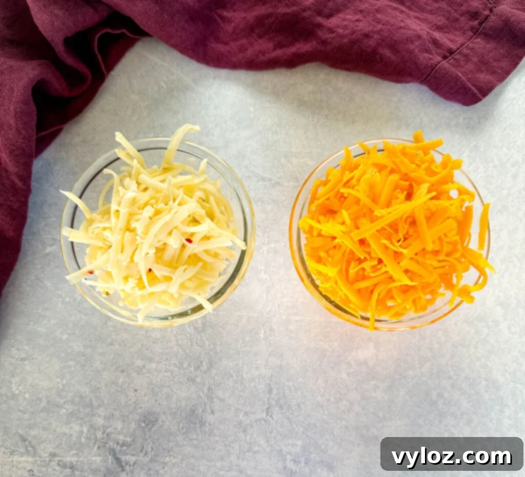 Glass bowls filled with freshly shredded cheddar jack and sharp cheddar cheese