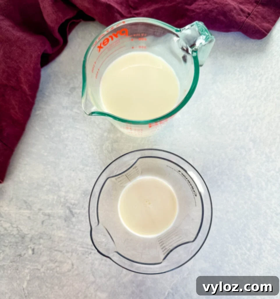 Separate bowls of whole milk and half and half, ready for blending into the queso