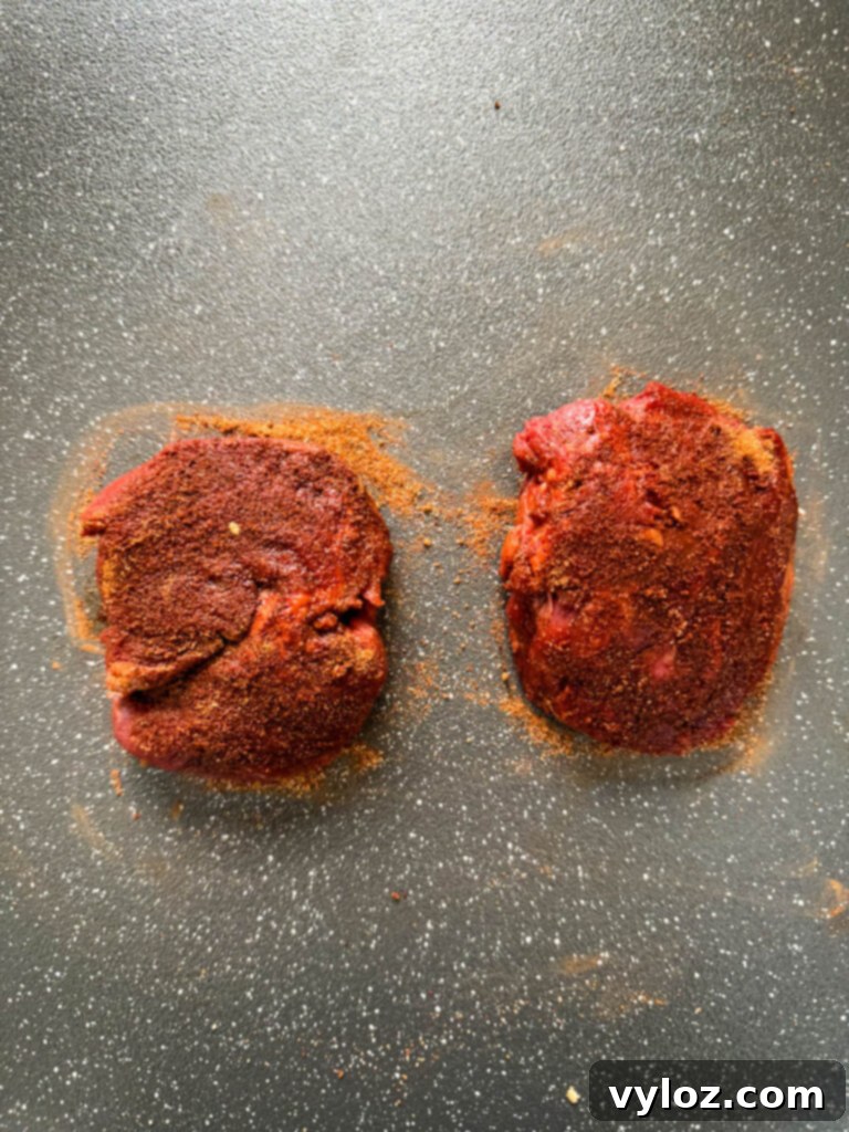 raw seasoned filet mignon on a plate