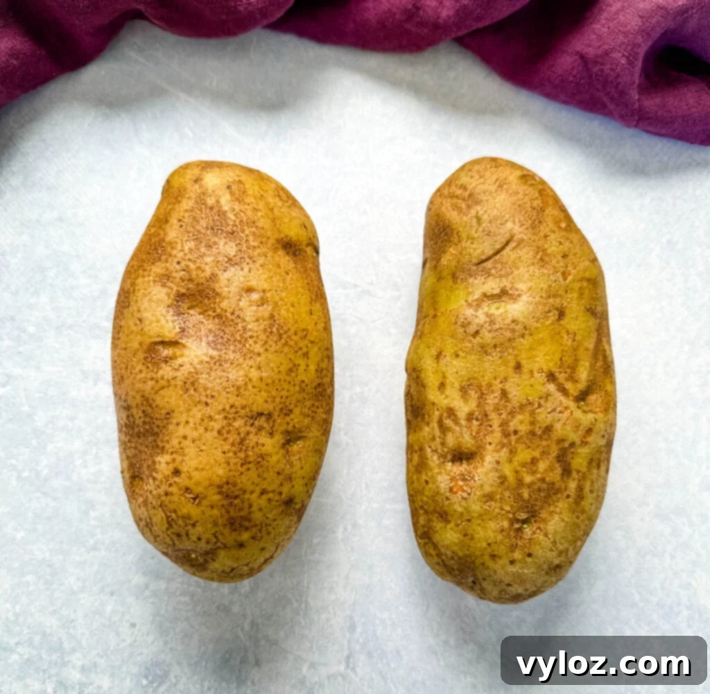 Traeger Smoked Baked Potatoes 3 russet potatoes on a flat surface