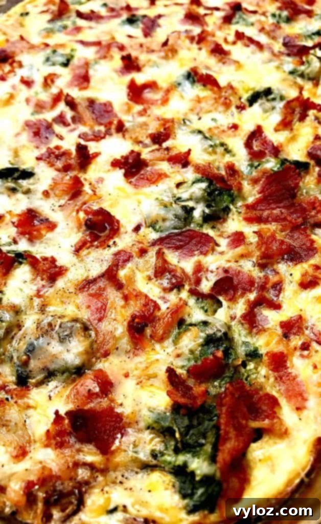 Close-up photo of a serving of Low-Carb Bacon, Egg, and Spinach Breakfast Casserole, showcasing the golden-brown top and visible ingredients