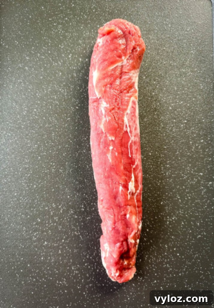 raw pork tenderloin on a flat surface, ready for seasoning