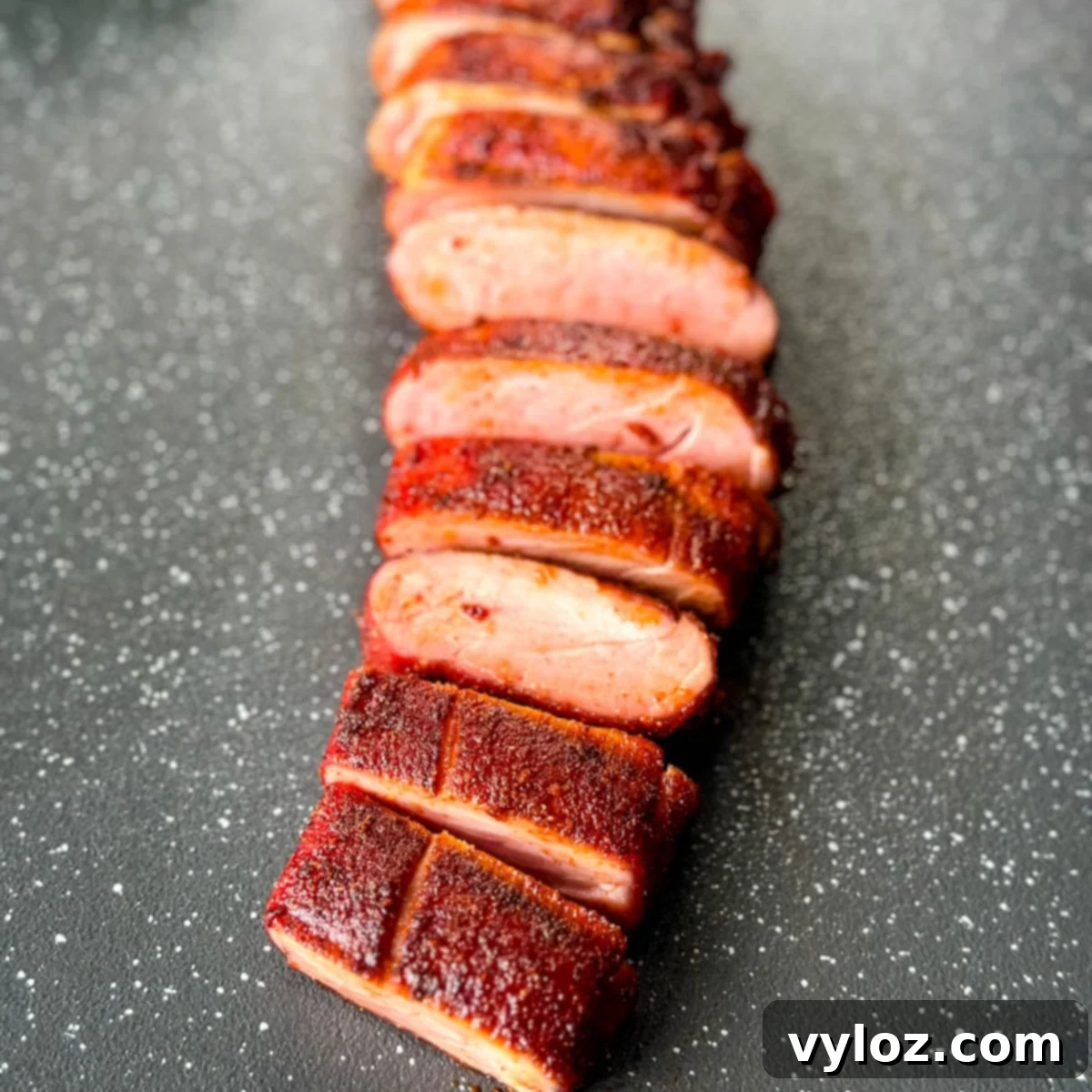 sliced smoked pork tenderloin on a flat surface, ready to be served
