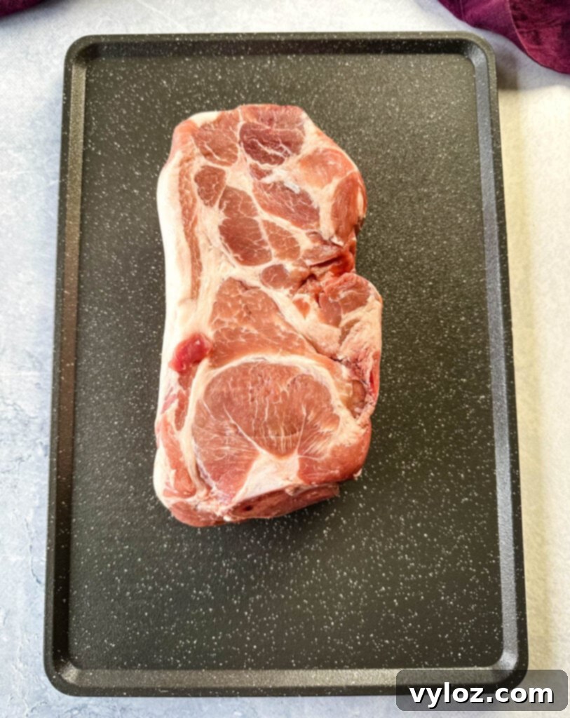 raw pork shoulder on a sheet pan
