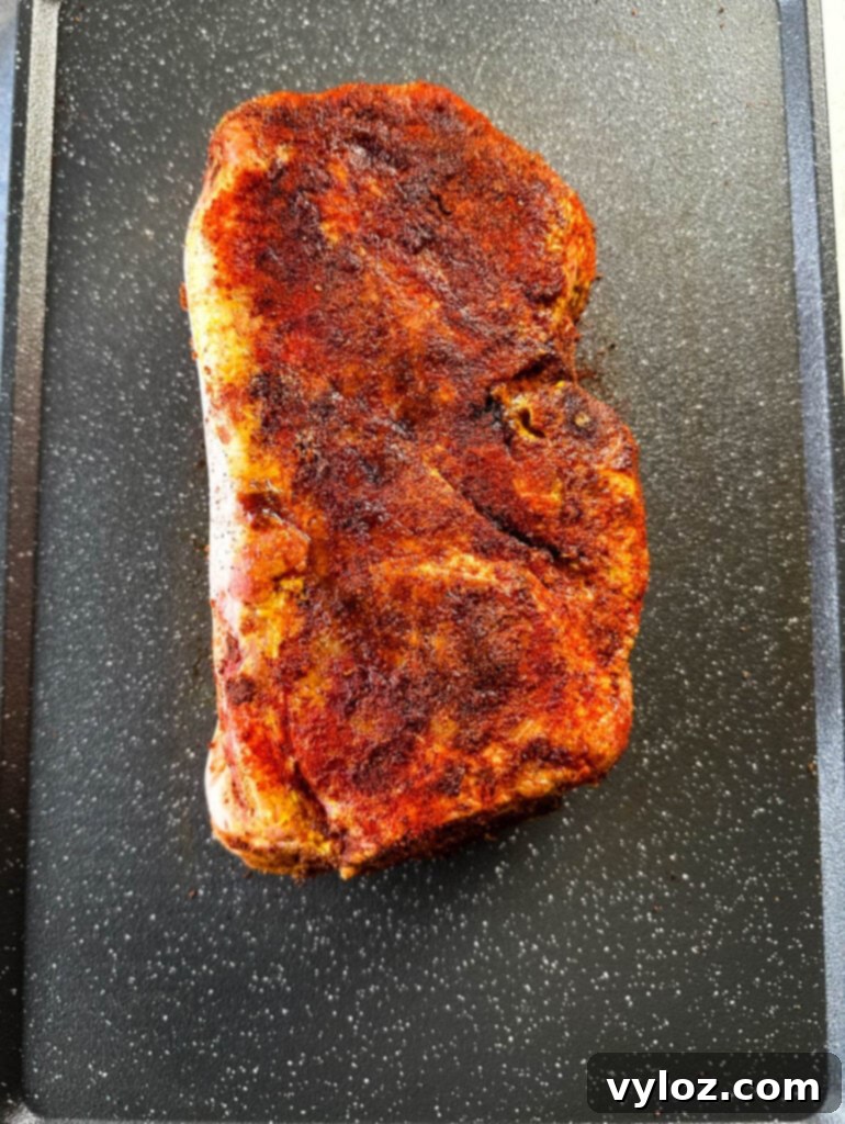 raw seasoned pork shoulder on a sheet pan
