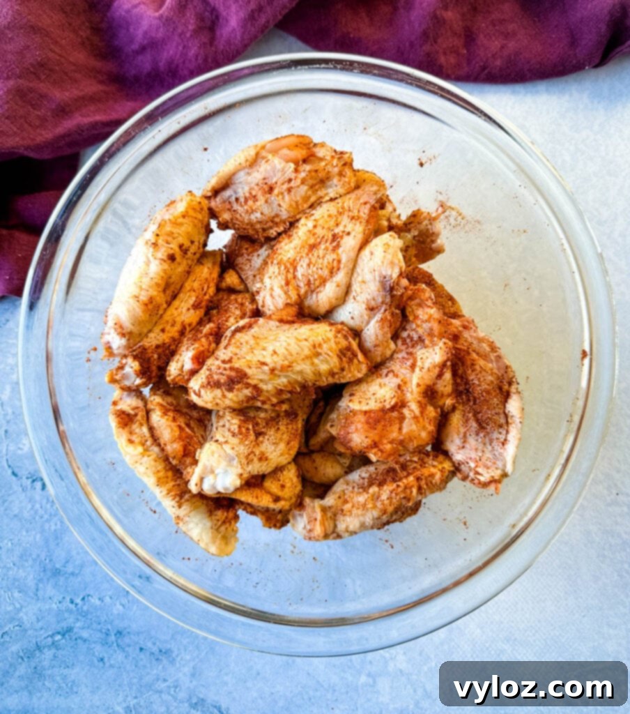 raw seasoned chicken wings in a glass bowl