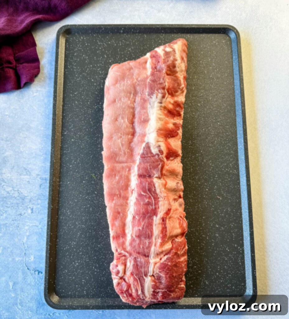 Slow Cooker BBQ Spare Ribs 3 Raw pork ribs laid out on a clean flat surface, ready for preparation