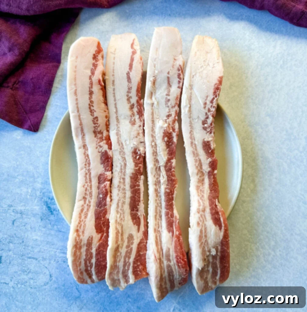 Umami Pork Belly Ramen 3 raw pork belly strips on a plate