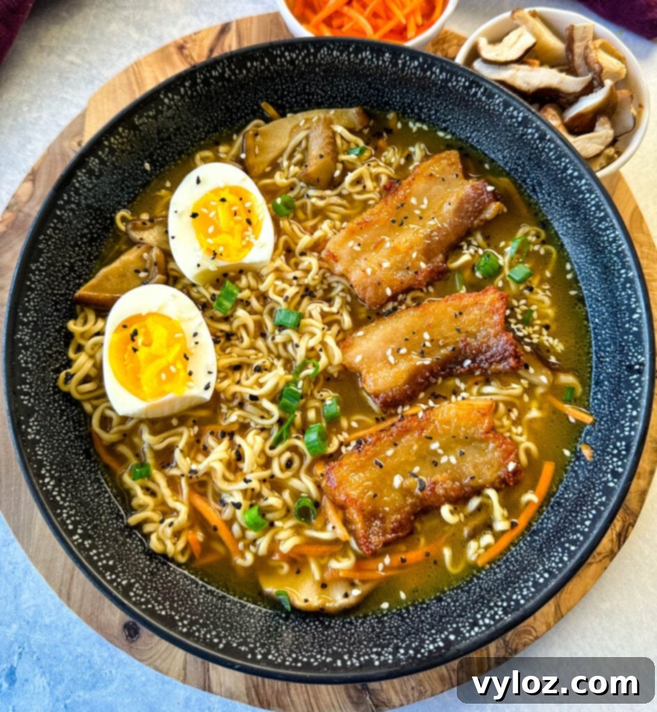 Umami Pork Belly Ramen 9 pork belly ramen with soft boiled eggs, green onions, and sesame seeds in a bowl