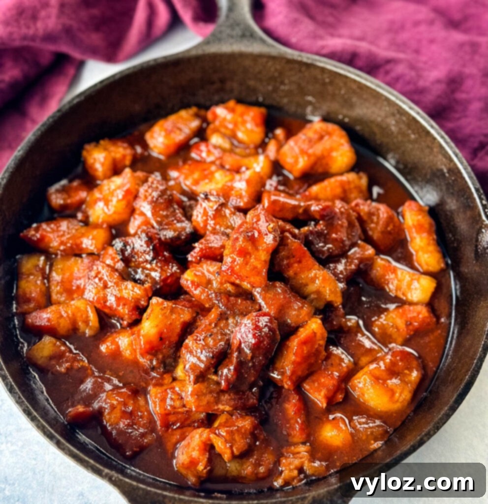 Traeger smoked pork belly burnt end with BBQ sauce in a cast iron skillet