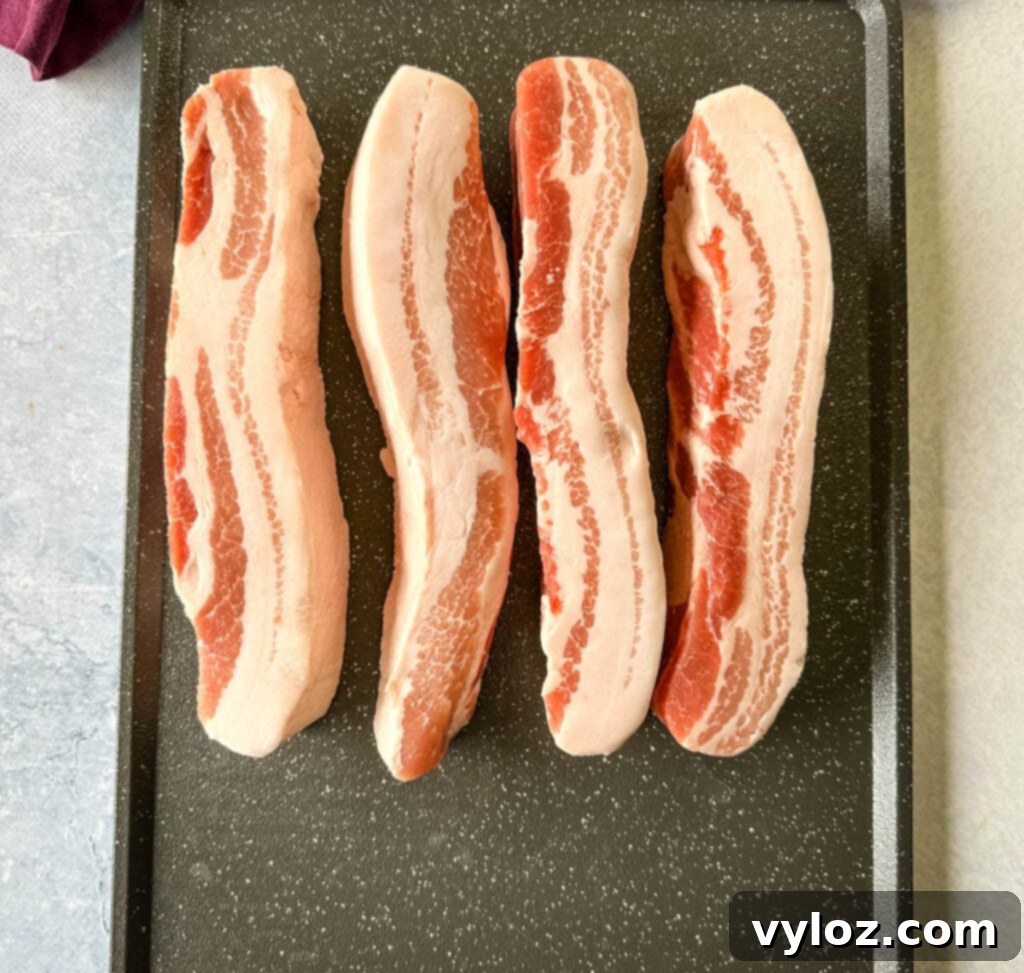 raw pork belly strips on a sheet pan