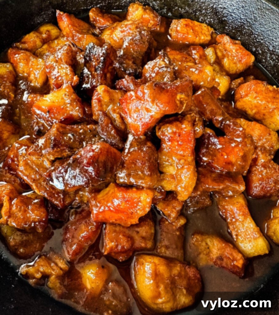 Traeger smoked pork belly burnt end with BBQ sauce in a cast iron skillet