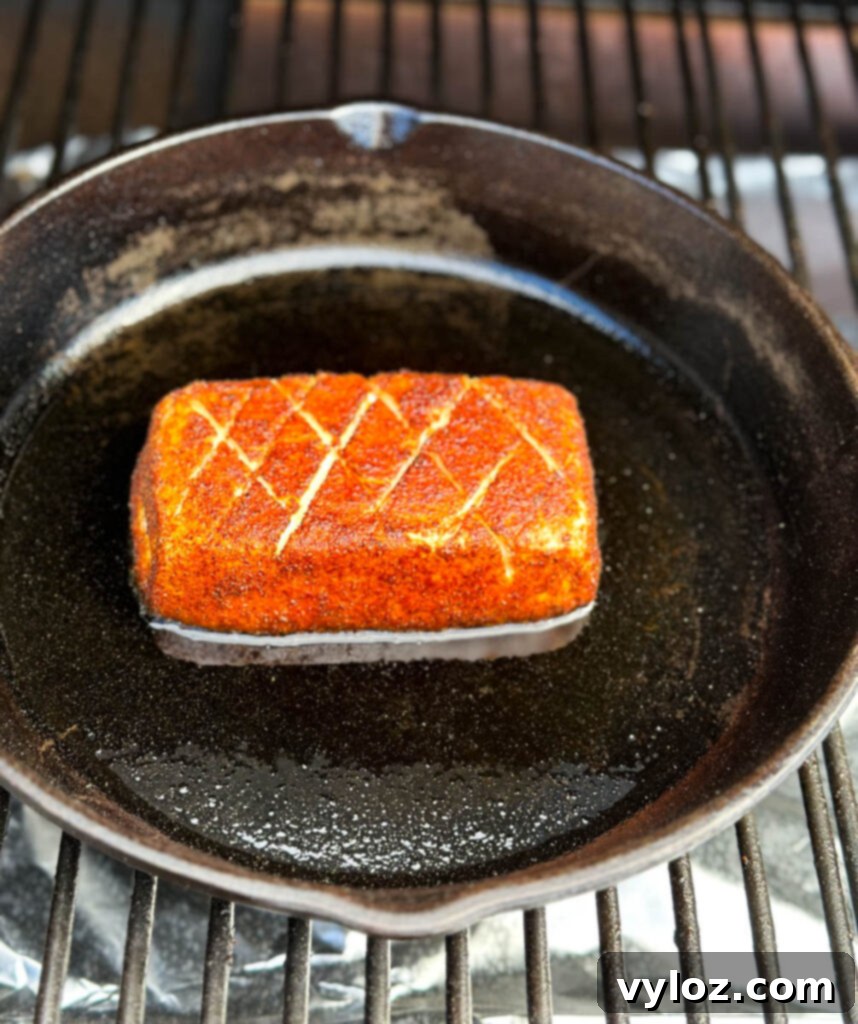 smoked cream cheese in a cast iron skillet on a Traeger pellet grill
