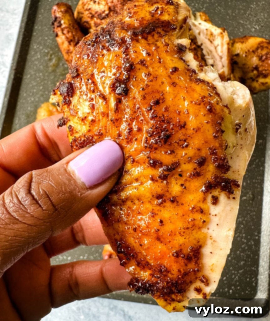 Smoked Beer Can Chicken Perfection 11 person holding a slice of Traeger beer can chicken