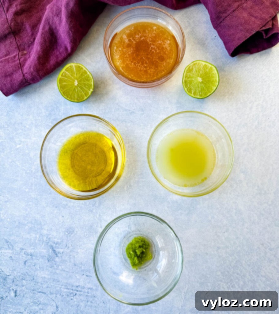 Four glass bowls neatly arranged, each containing a primary ingredient for the dressing: golden honey, rich olive oil, freshly squeezed lime juice, and finely grated lime zest.