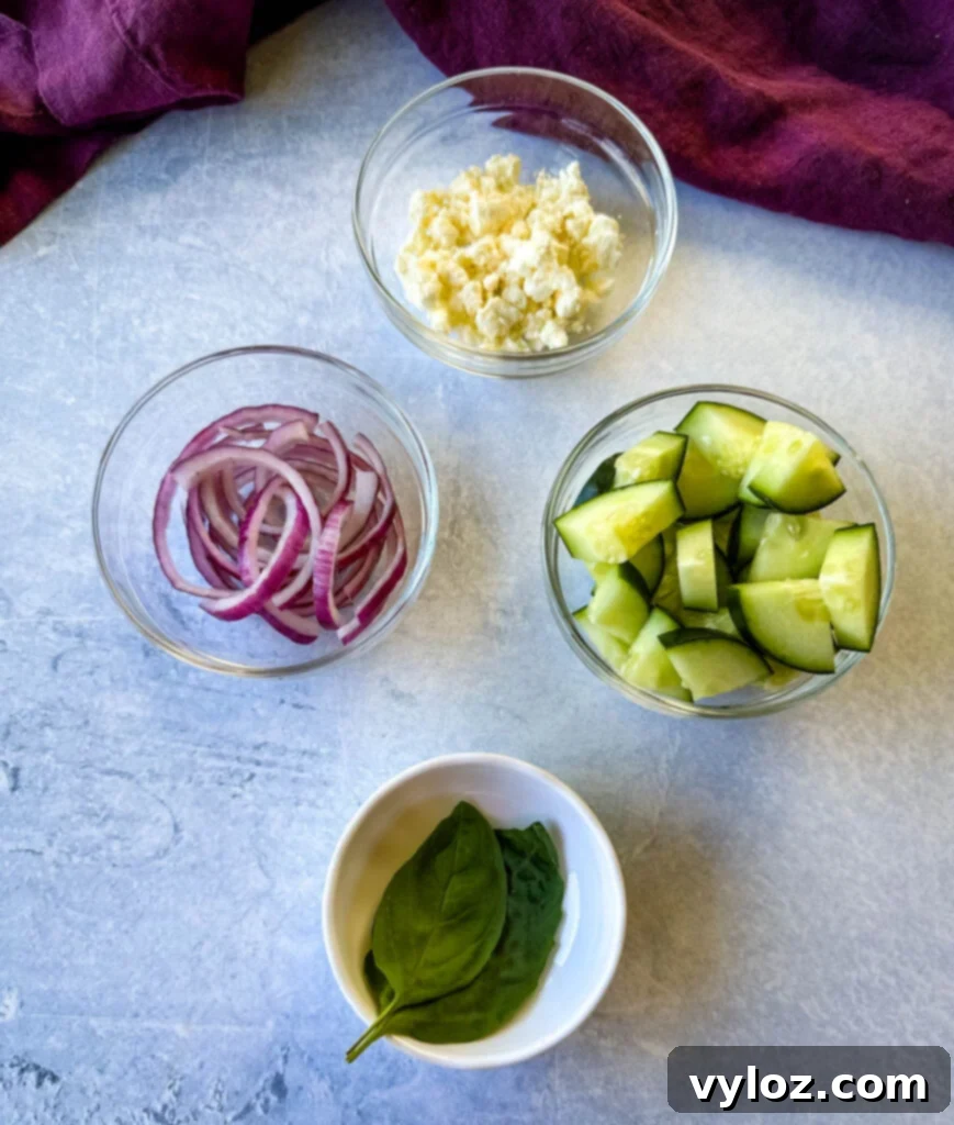 Vibrant Watermelon Feta Salad with Balsamic 4 red onions, feta, cucumbers, and fresh basil in separate glass bowls