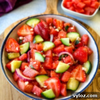 Vibrant Watermelon Feta Salad with Balsamic 10 watermelon salad with feta, basil, cucumbers, avocado, strawberries, onion, and balsamic lime dressing in a white bowl