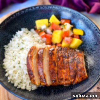 Blackened Chicken 11 blackened chicken breasts with rice and mango salsa in a black bowl