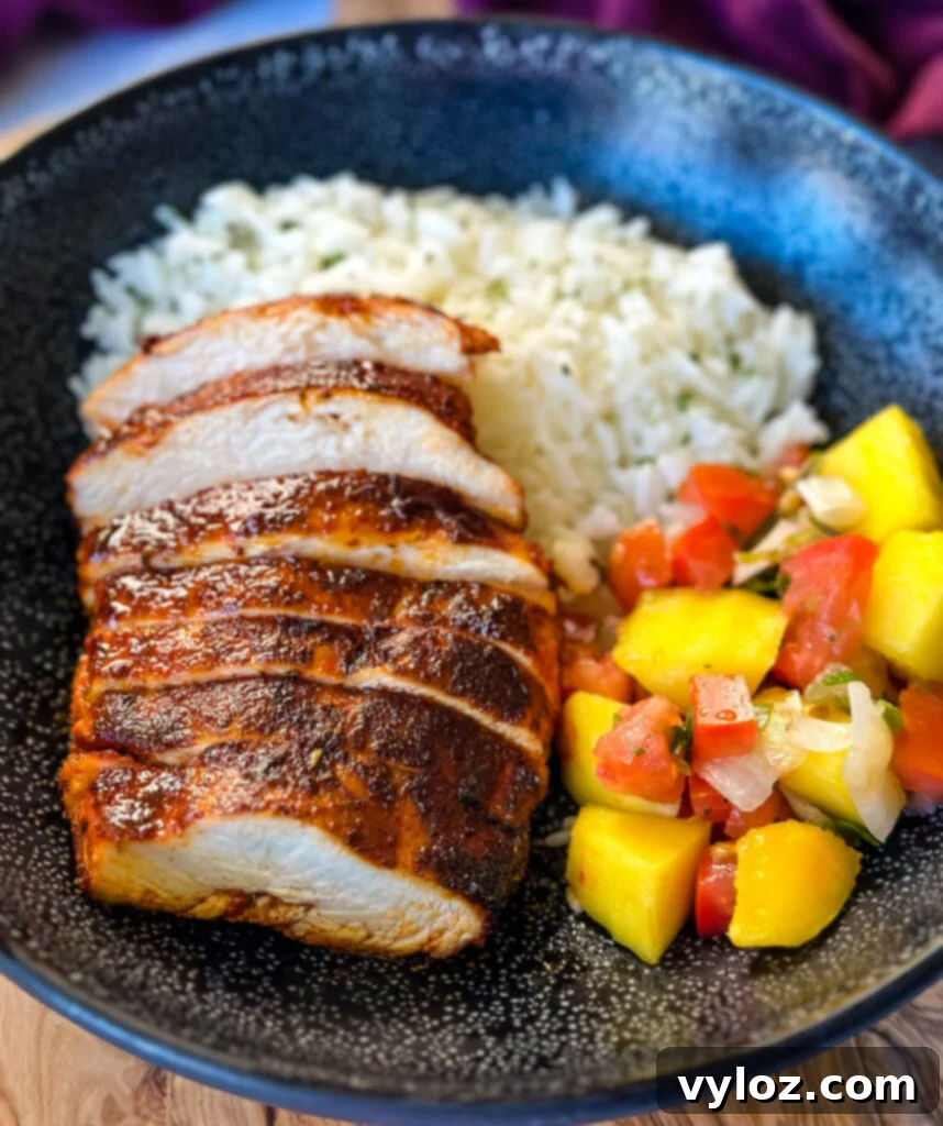 Blackened Chicken 9 blackened chicken breasts with rice and mango salsa in a black bowl