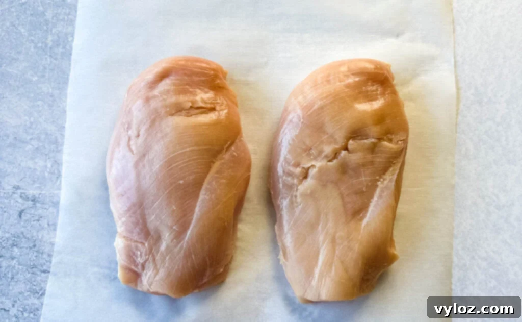 raw chicken breast on parchment paper