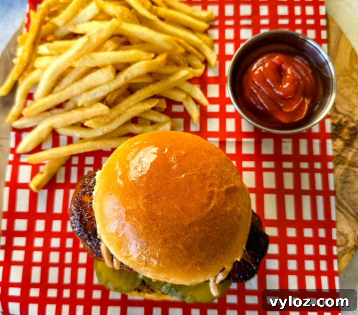 blackened chicken sandwich on a bun with spicy mayo on a plate with fries