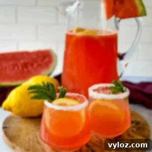 Watermelon lemonade in glasses and a pitcher with fresh watermelon and lemons