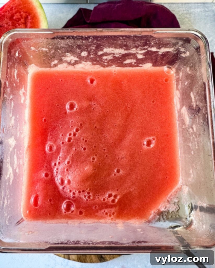 Watermelon Slush Margarita 7 Close-up of frozen watermelon margaritas in a blender, showing the vibrant color and icy texture