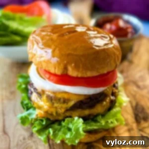 Traeger smoked burger on a bun with cheese, lettuce, tomato, and onions