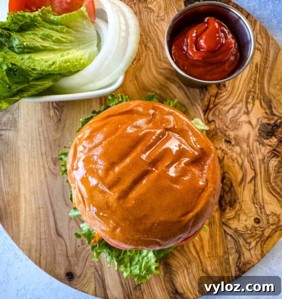 Traeger smoked burger on a bun with cheese, lettuce, tomato, and onions