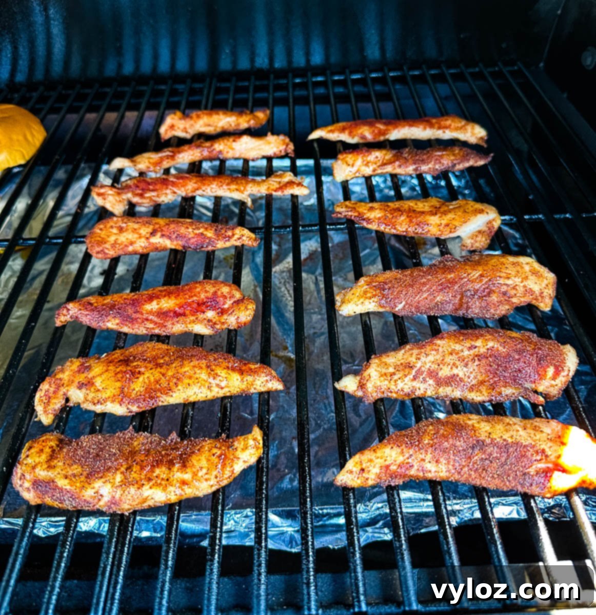 smoked chicken tenders cooking on a Traeger smoker grill, showing perfect color