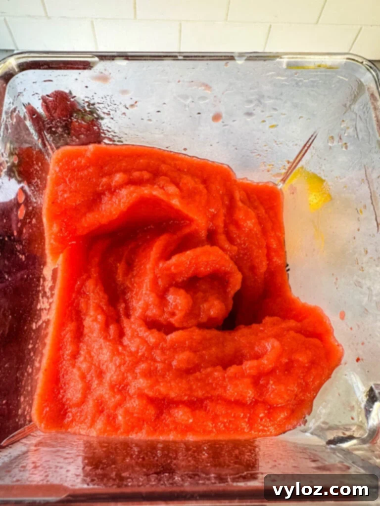 Frozen strawberry lemonade blending in a high-powered blender, creating a smooth, icy texture.
