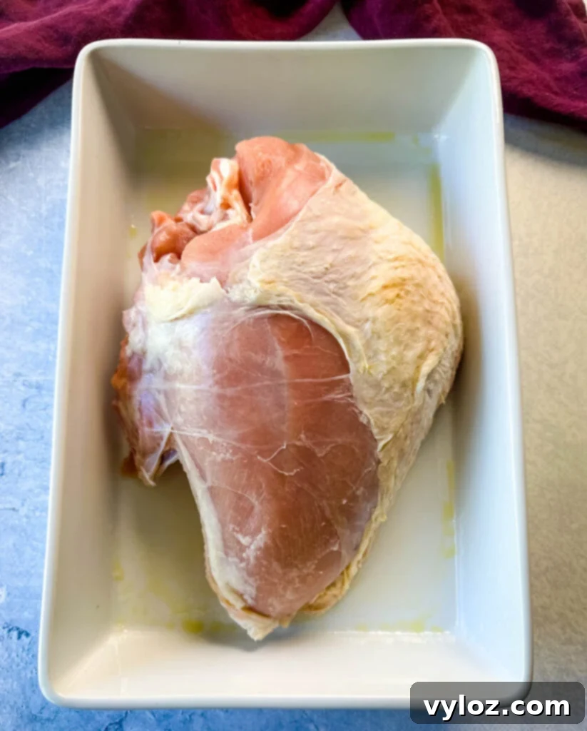 Juicy Bone-In Turkey Breast 3 raw bone in turkey breast in a white 9x13 baking dish