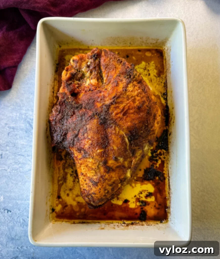 Juicy Bone-In Turkey Breast 7 baked roasted bone in turkey breast in a white 9x13 baking dis