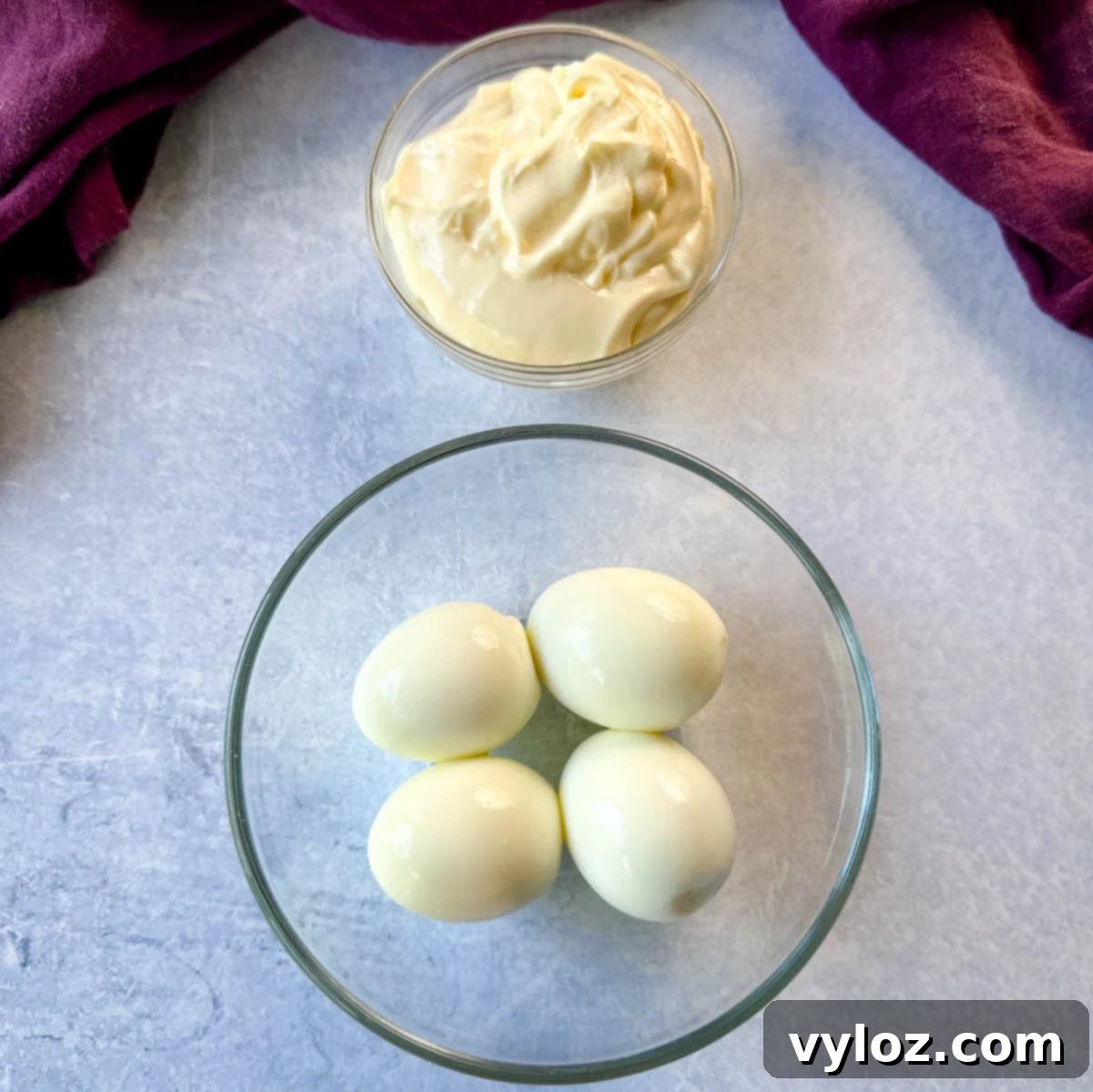 mayo and peeled hard boiled eggs in separate glass bowls