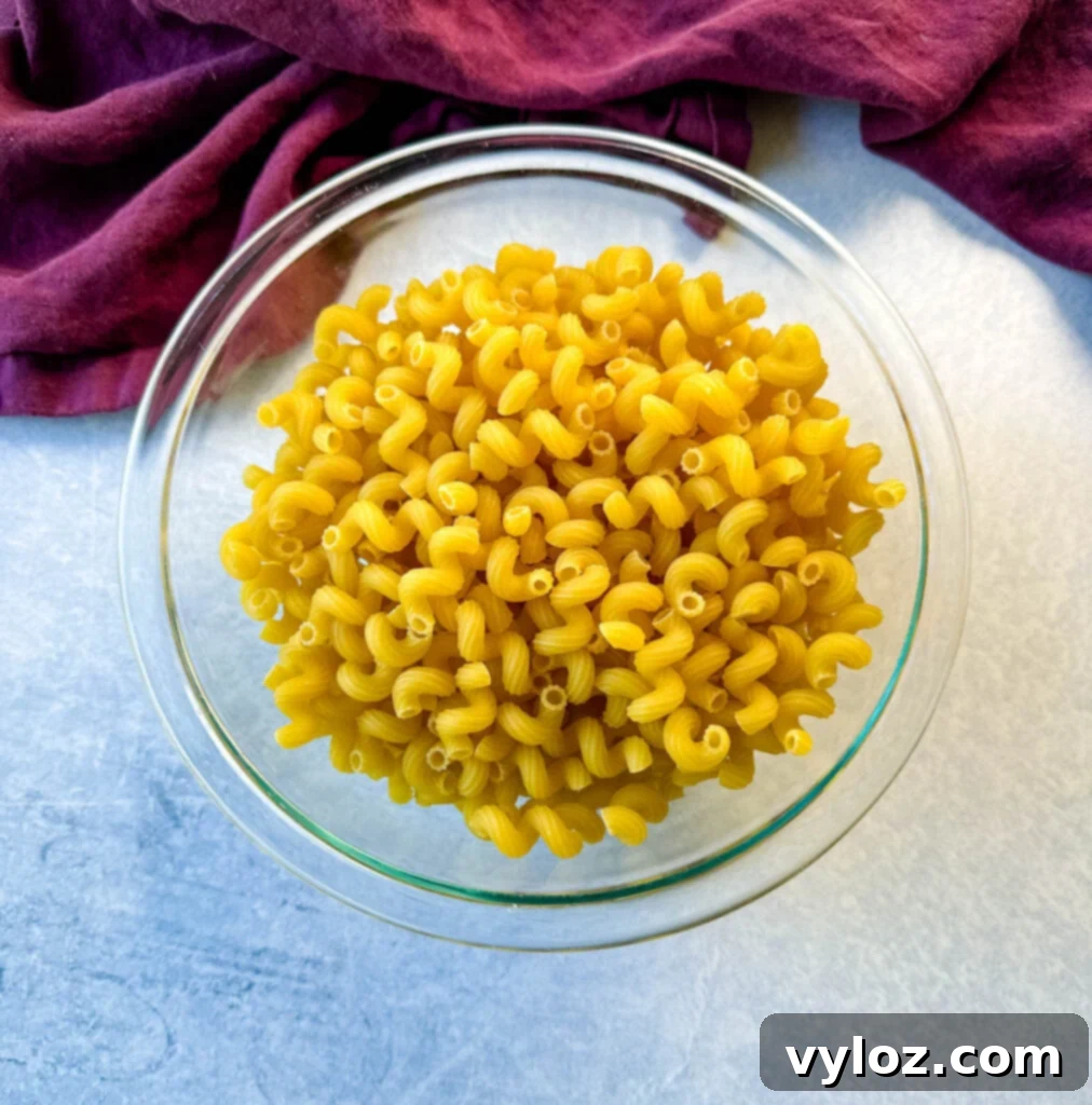 Effortless Crockpot Mac and Cheese 4 dry corkscrew pasta in a glass bowl