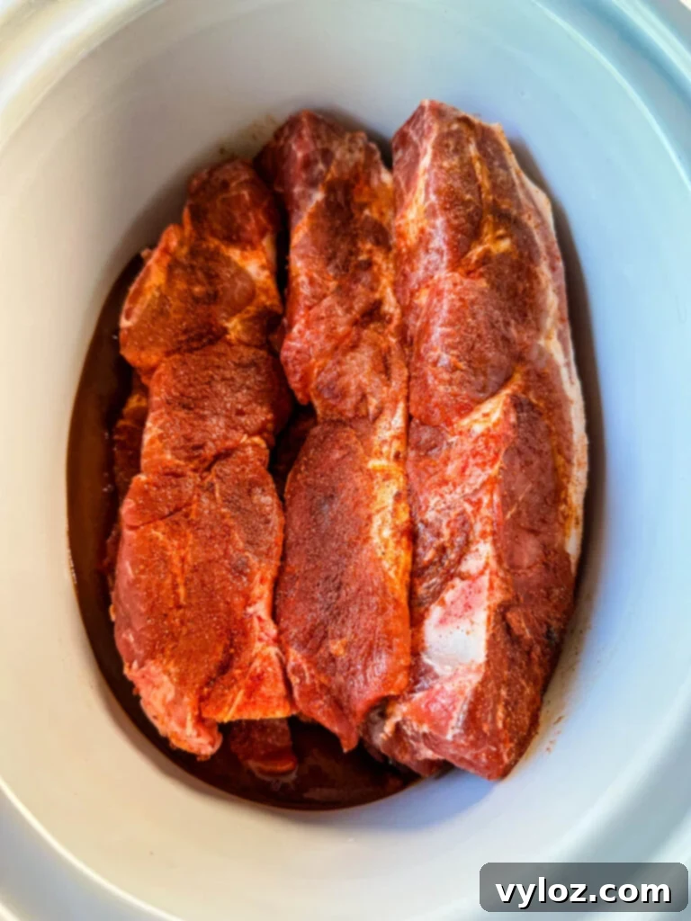 raw country style ribs with BBQ sauce in a slow cooker Crockpot