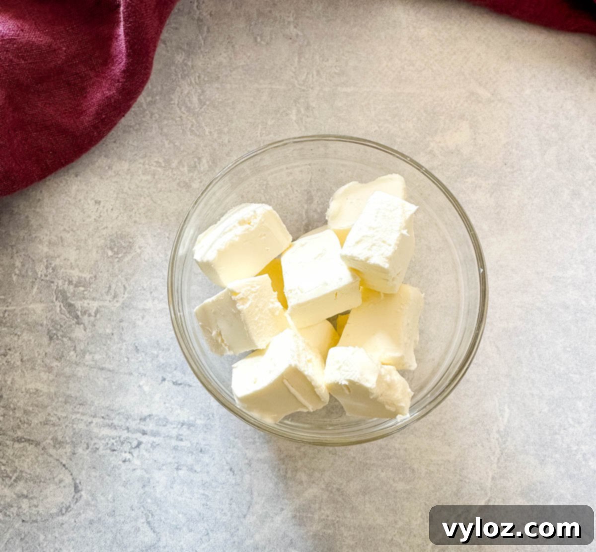 cream cheese cut into chunks in a glass bowl