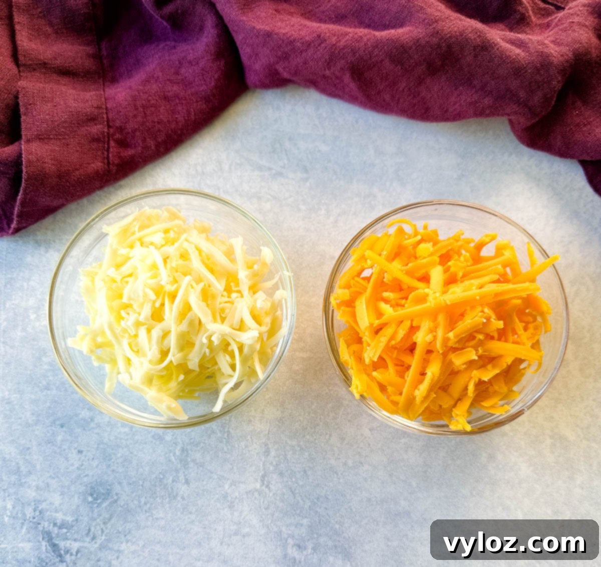 grated cheddar and Monterrey jack cheese in separate glass bowls