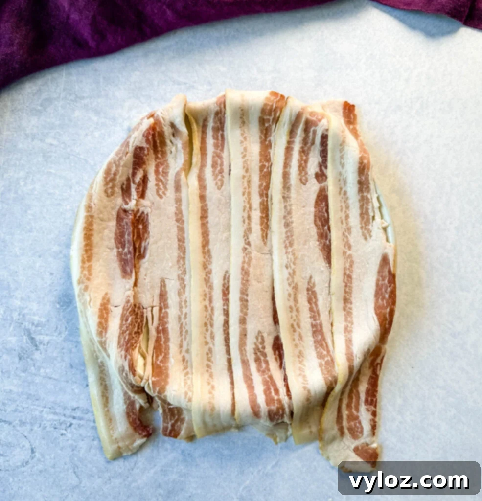 Slices of crispy bacon on a plate, ready to be crumbled into the casserole