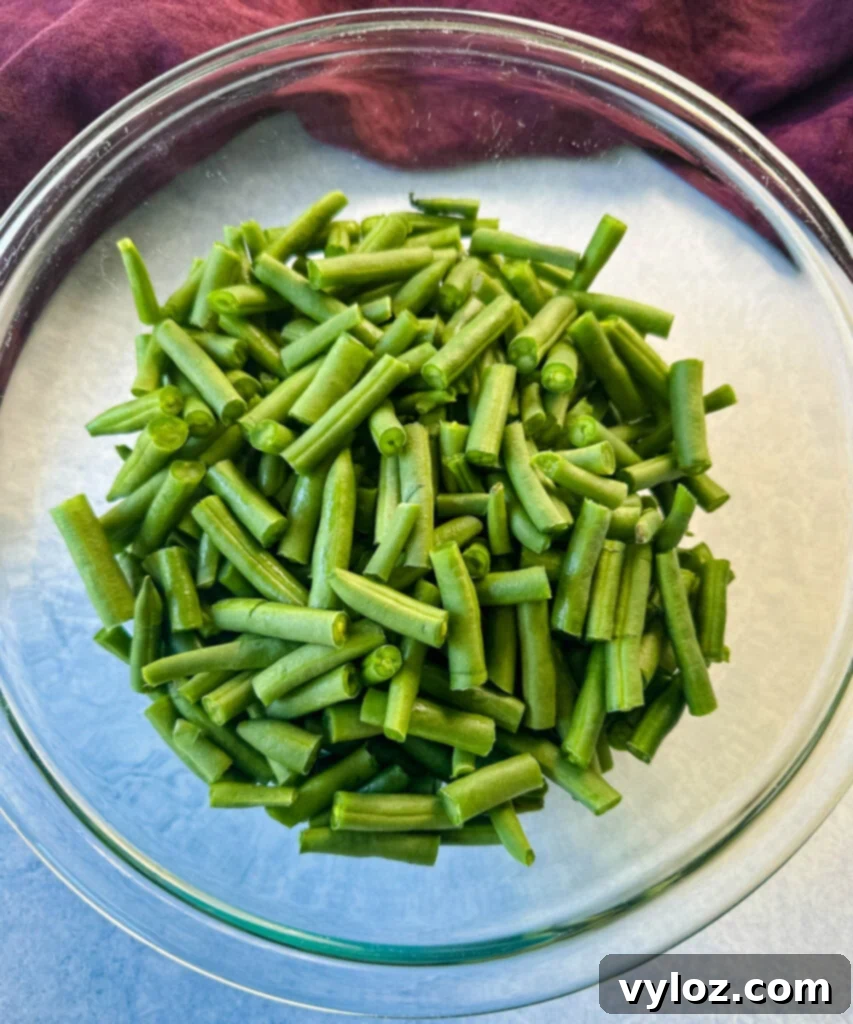 Fresh, cut green beans in a glass bowl, ready for cooking