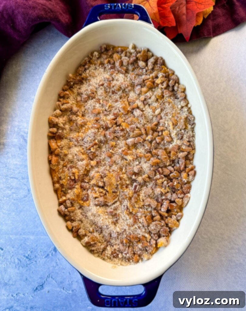 Golden Sweet Potato Pecan Delight 8 Unbaked sweet potato casserole with a generous layer of pecan streusel topping in a glass baking dish.