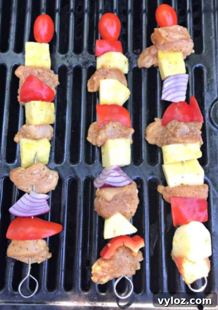 Aloha Grilled Chicken and Pineapple Skewers 3 Close-up of perfectly grilled Hawaiian pineapple chicken skewers with vibrant colors of chicken, pineapple, and red bell pepper.
