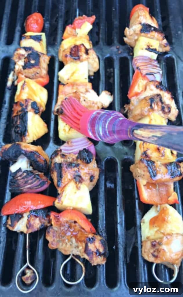 Aloha Grilled Chicken and Pineapple Skewers 4 Close-up of Hawaiian pineapple chicken skewers being grilled, showing beautiful char marks and glistening glaze.