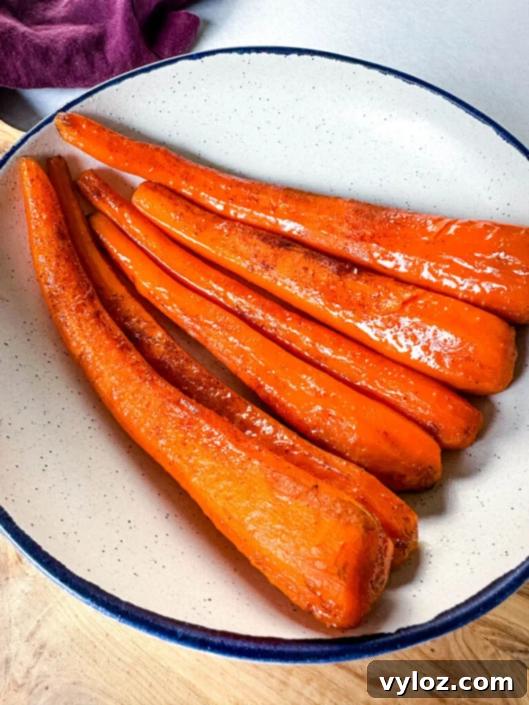 A serving of slow cooker Crockpot glazed carrots in a white bowl, ready to be enjoyed.