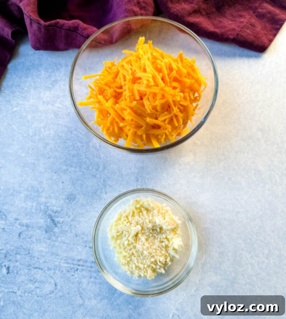 grated cheddar and Parmesan cheese in separate glass bowls