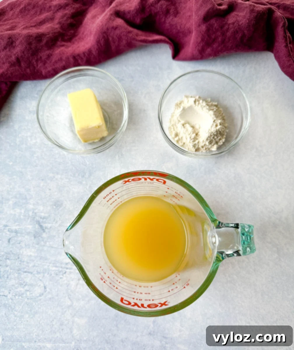 Unsalted butter, all-purpose flour, and broth in separate glass bowls, ready for making gravy