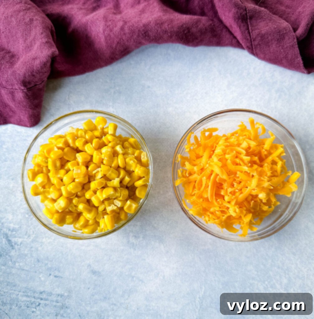 Bowls of fresh sweet corn and shredded cheddar cheese, ready as ingredients for a homemade KFC Famous Bowl.