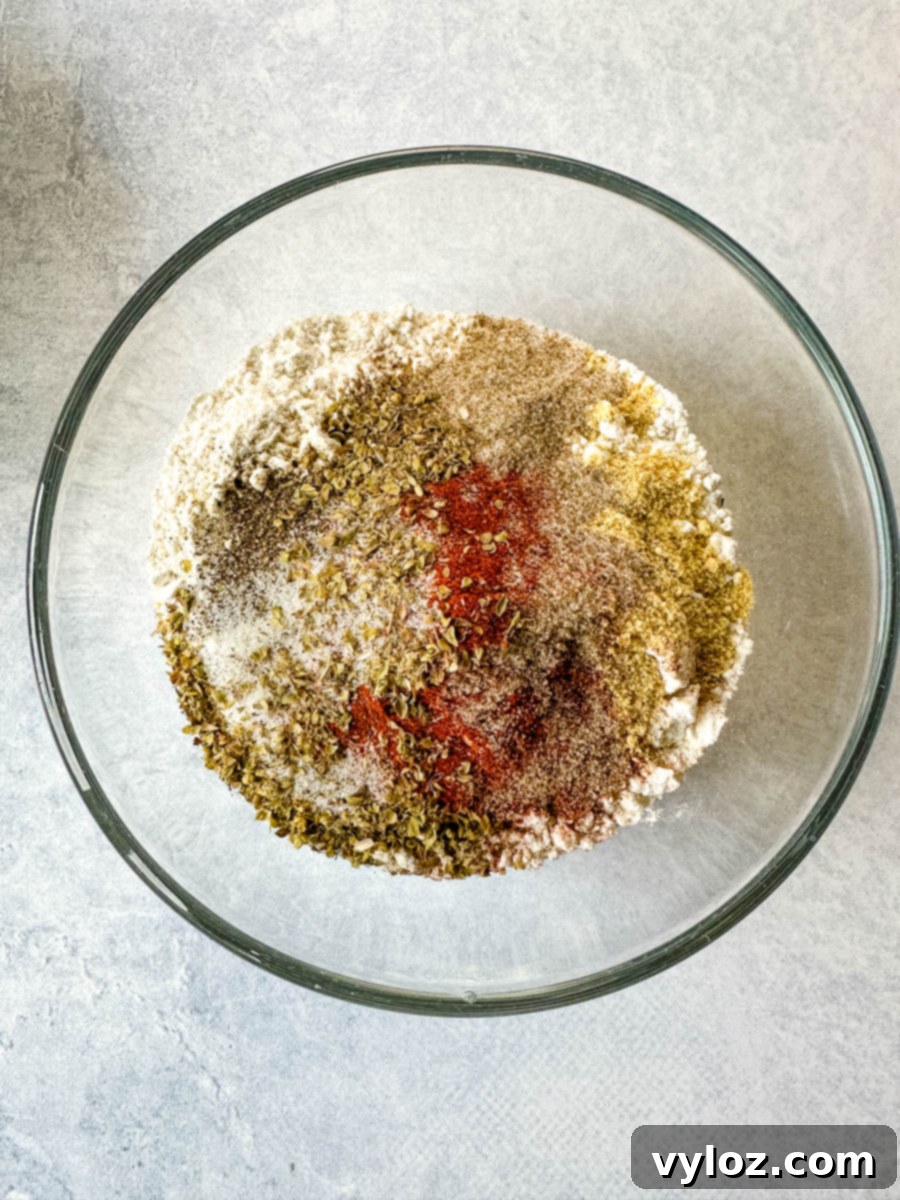 A mix of 11 herbs and spices with flour in a glass bowl, ready for breading the chicken.