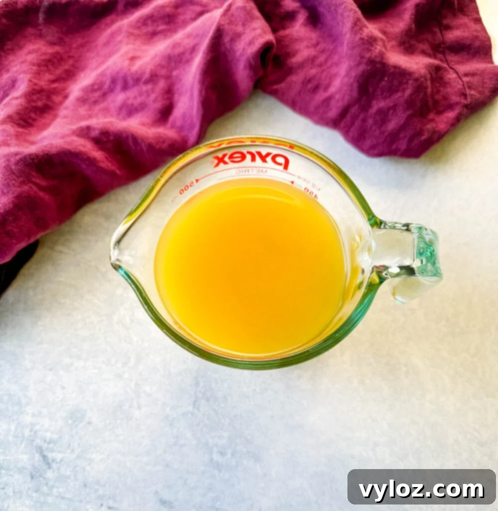 chicken broth in a glass measuring cup